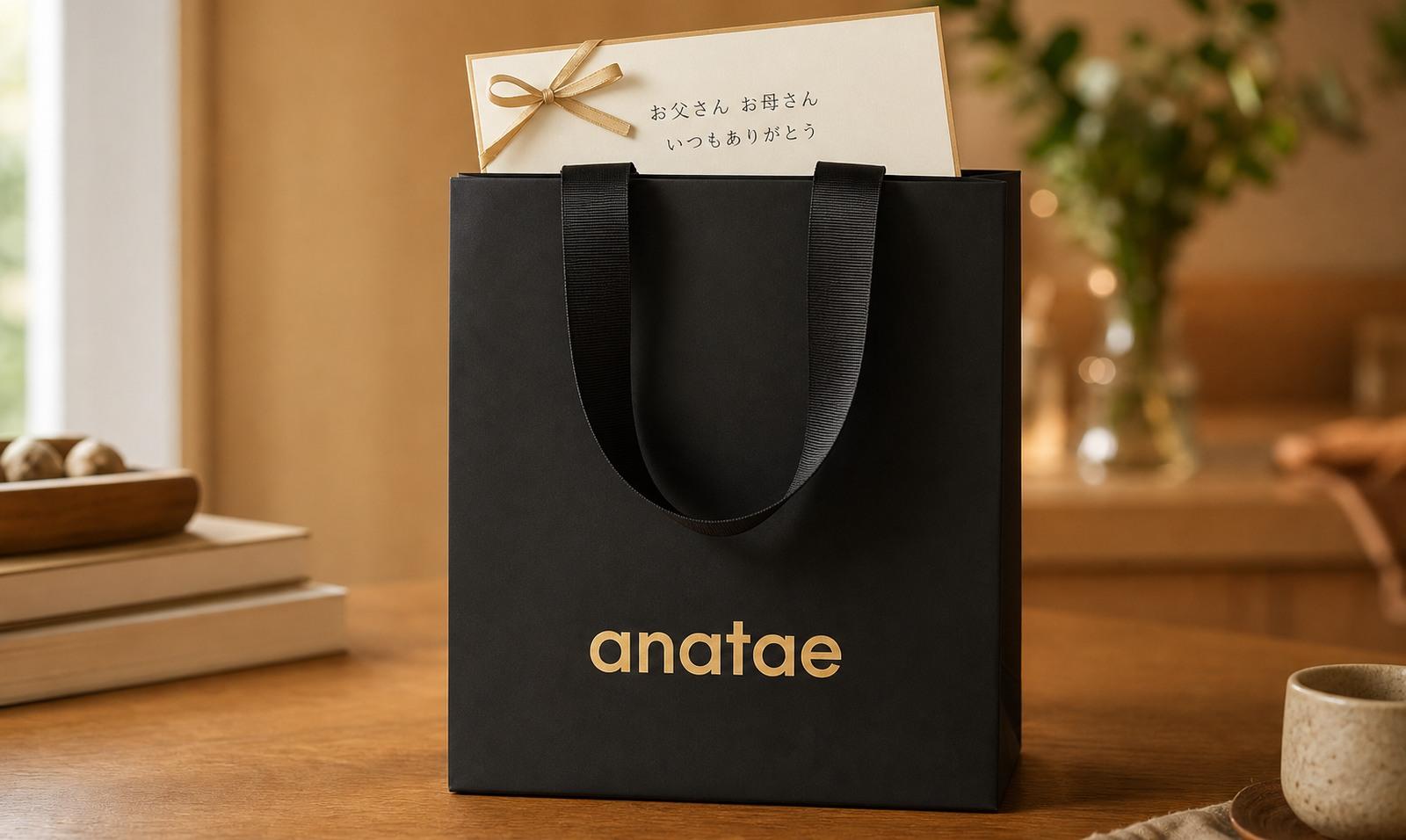 両親への旅行プレゼント。anataeの黒い紙袋と「お父さん お母さん いつもありがとう」メッセージカード