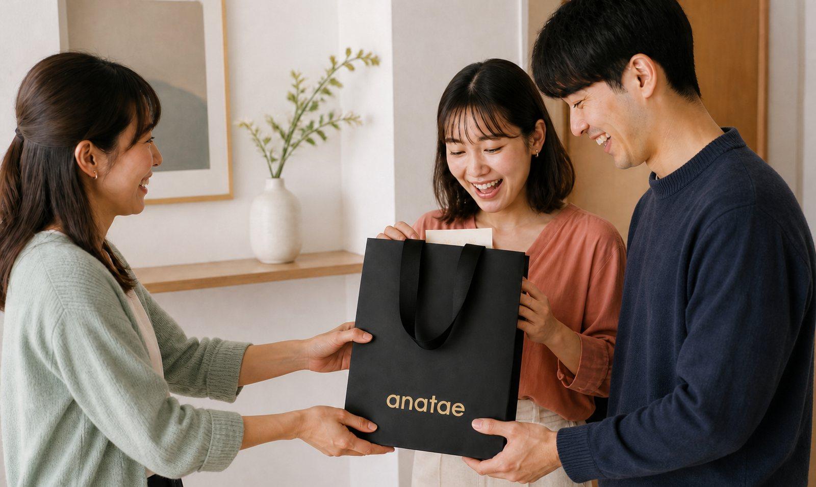 友人が新婚のお二人へ anatae の黒いプレミアム紙袋を手渡す結婚祝い